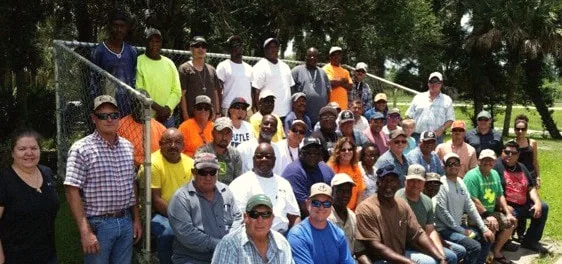 A large group of Hundley Farms employees gathered together outdoors